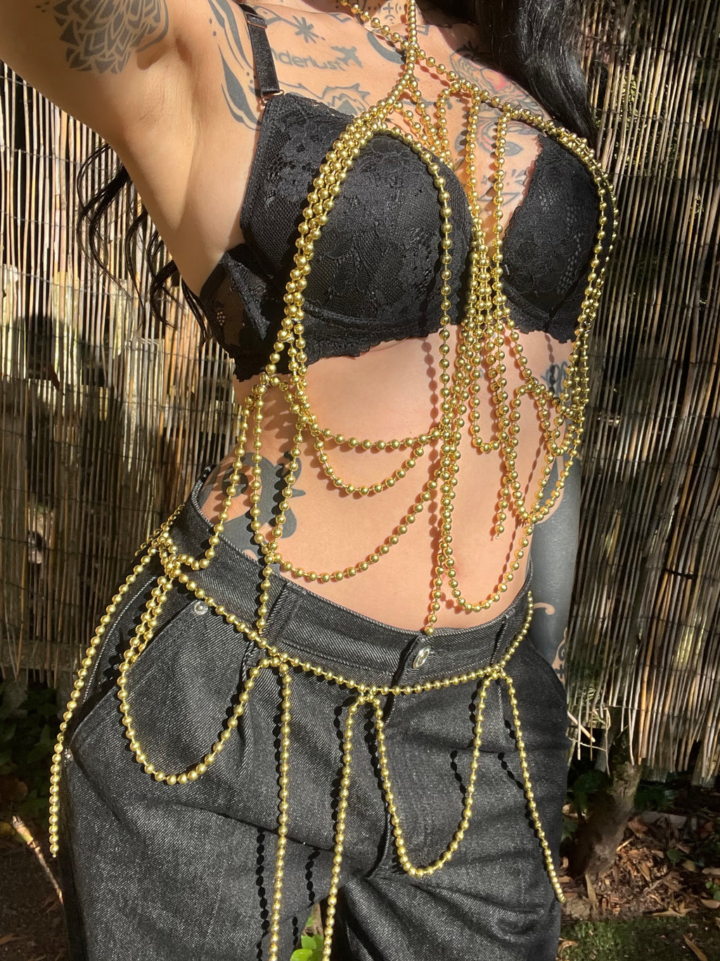 Golden Serpent handmade gold-tone brass ball-chain body harness and waist belt by NiX Jewelry, displayed on a mannequin outdoors.
