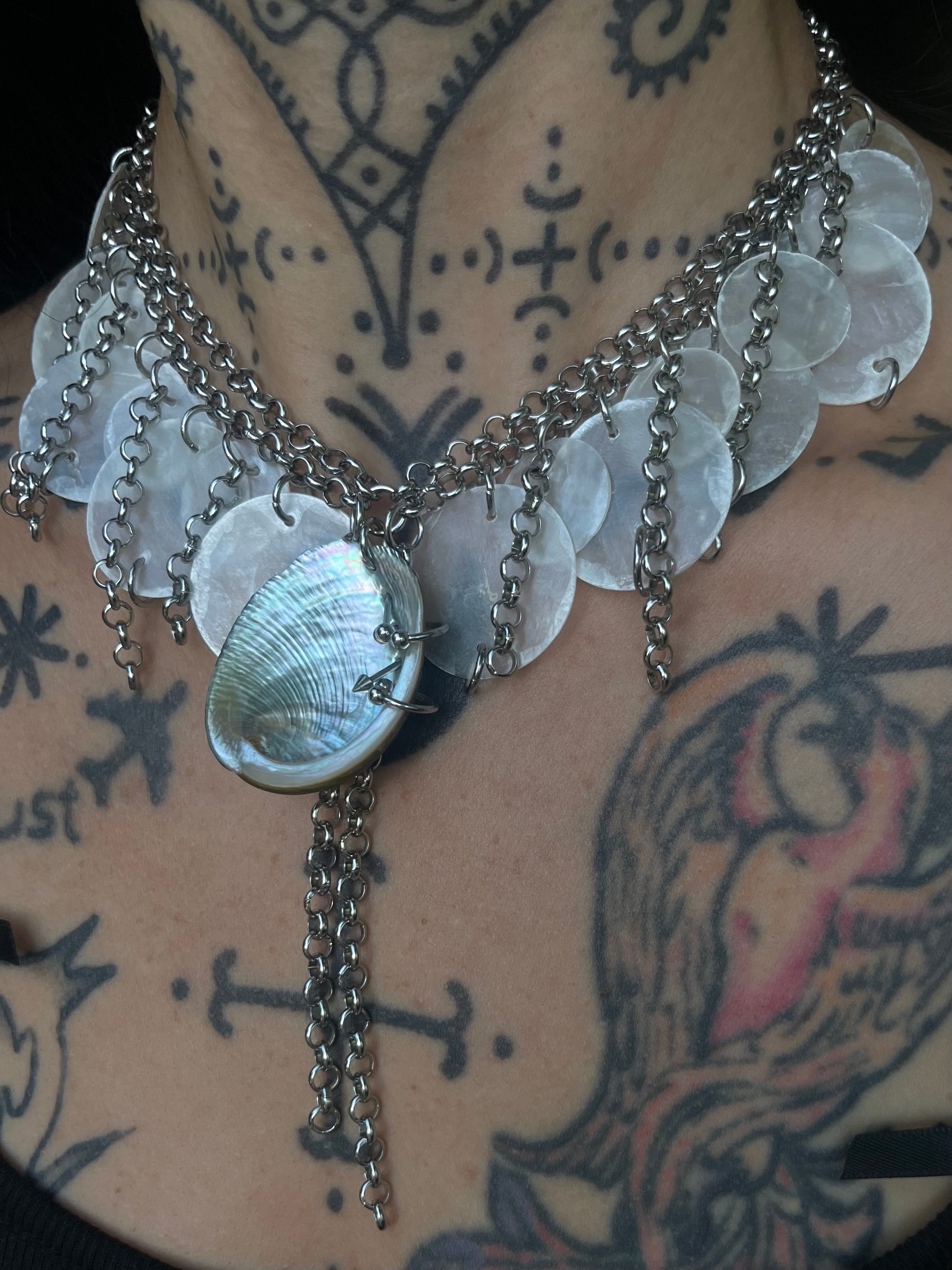 Handmade shell statement necklace with translucent shell discs, iridescent shell centerpiece and layered silver-tone chains